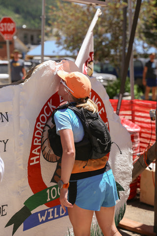 Annie Hughes kisses the iconic rock at the finish line of the Hardrock race